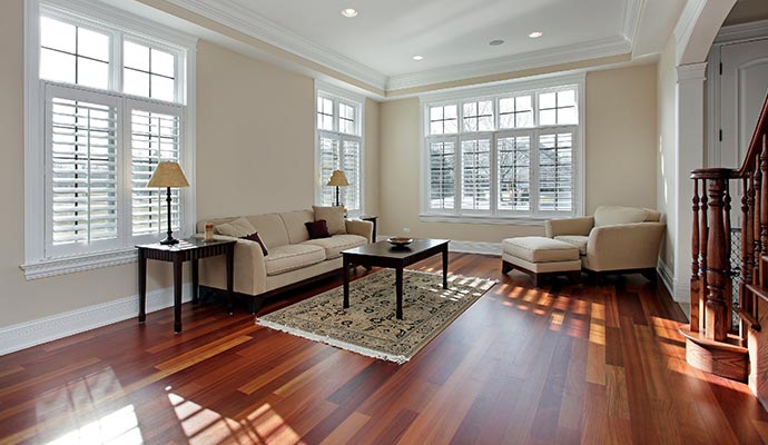 A bright living room with polished hardwood floors, showcasing the results of a professional flooring partnership and complete floor services