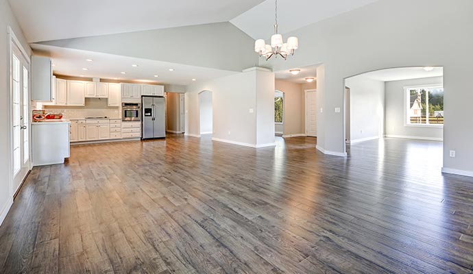 An open living space with freshly refinished hardwood floors showing a smooth, uniform, and restored surface