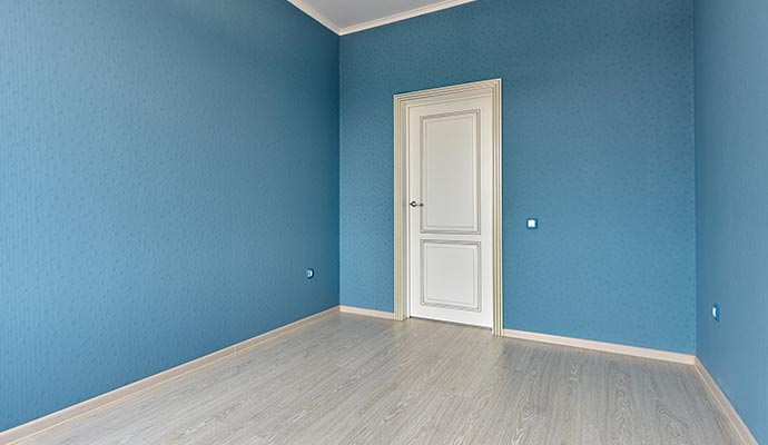 Empty room with blue walls and a white door