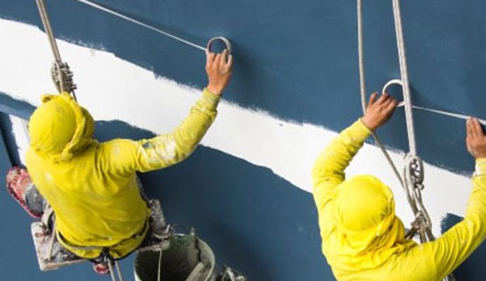 Professional painters applying exterior paint on a commercial building with precision and quality finish