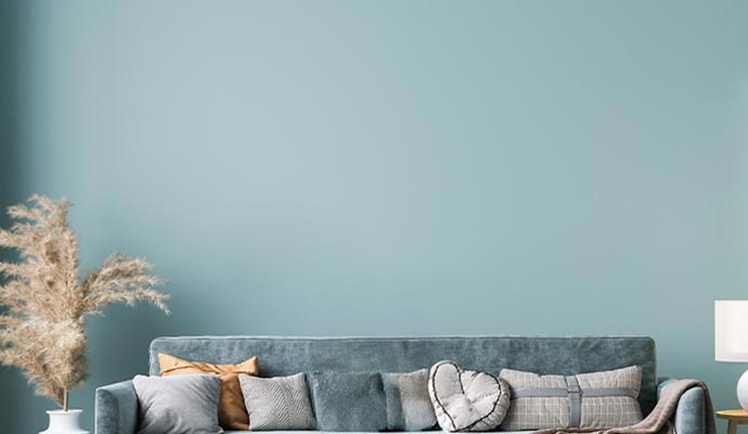 Interior wall painted with semi-gloss paint behind a sofa in a living room.