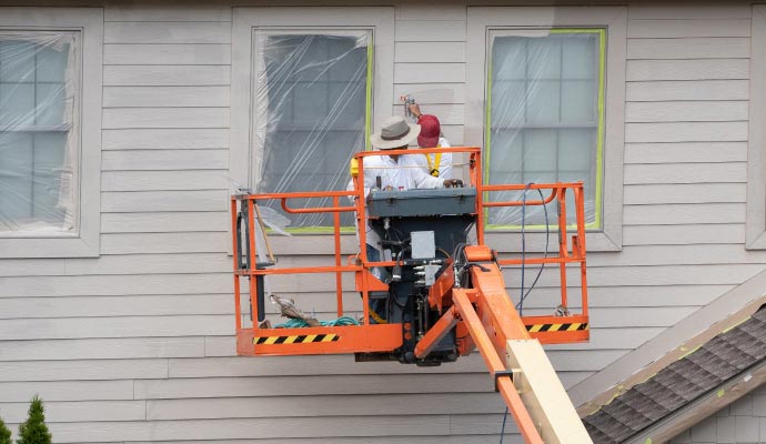 Professional painters painting the exterior walls of a warehouse