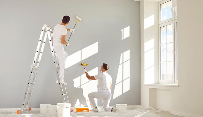Workers painting the walls of a store room, improving its appearance